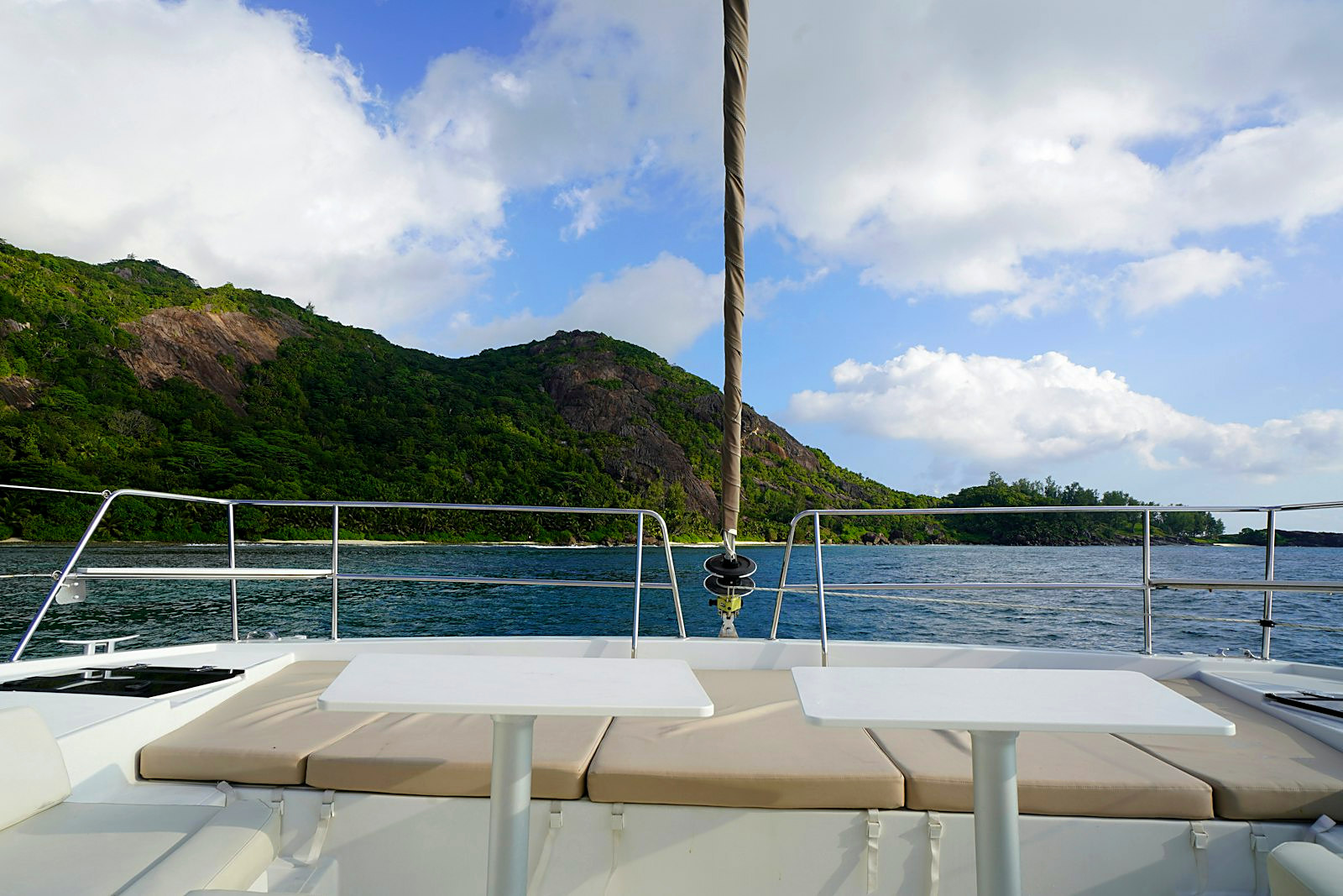 A catamaran anchored over turquoise water near a Seychelles reef